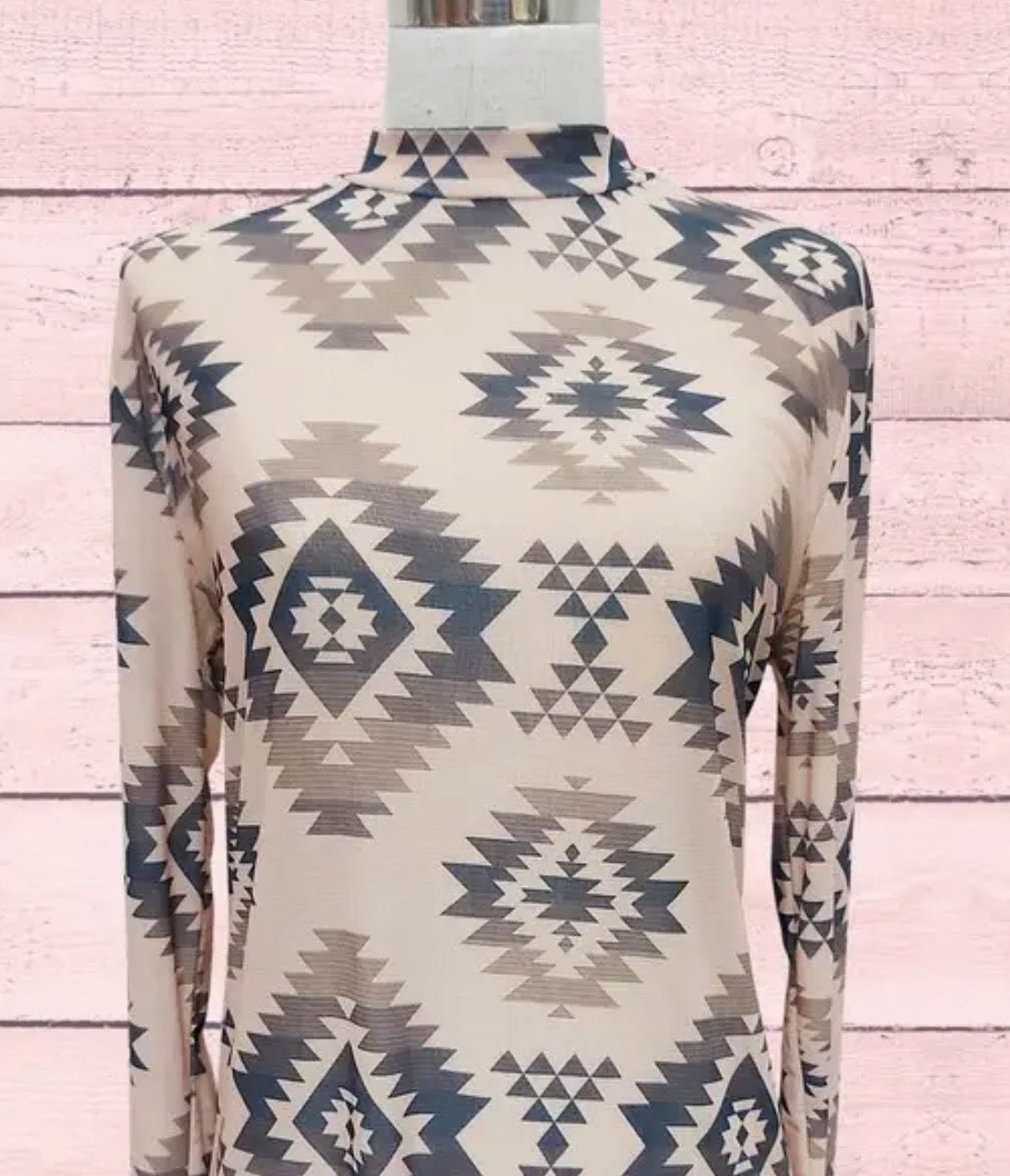 Long-sleeve top with geometric pattern on a mannequin against a wooden background